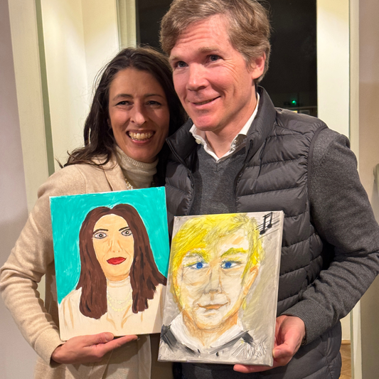 Two people holding self-portraits made by each other, one with brown hair and the other with blonde hair.